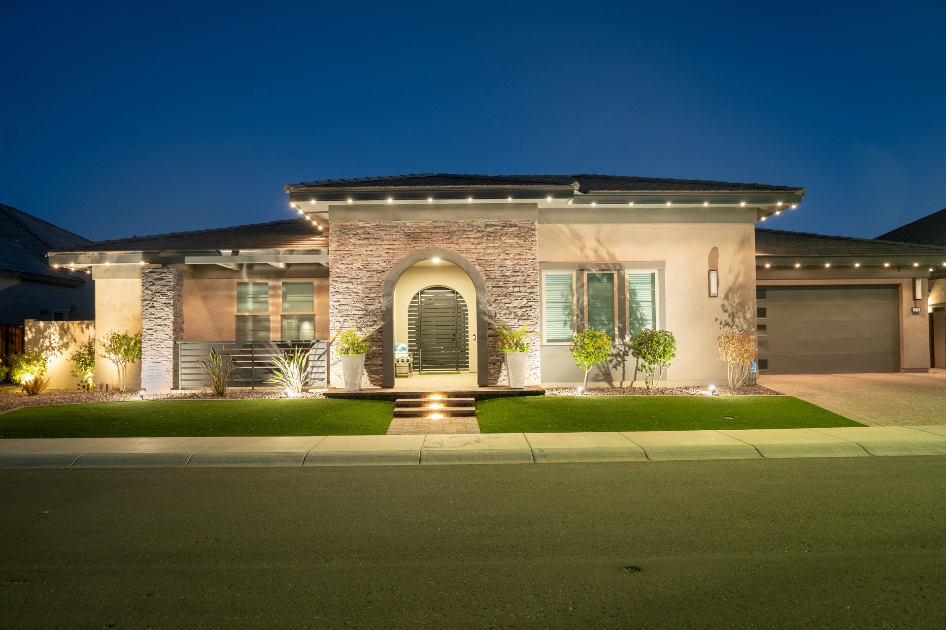 Home with permanent outdoor LED roofline lighting at night